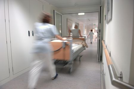 Zwei Menschen schieben in einem Krankenhaus ein Krankenbett
