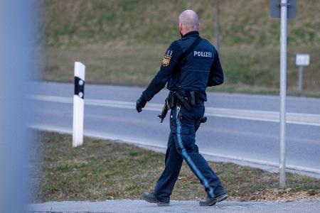 Ein bewaffneter Polizist geht auf einer Straße am Ortsrand von Parsberg.