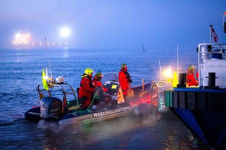 Einsatzkräfte der Wasserschutzpolizei sichern den Hafen, in dem das Spezialschiff 