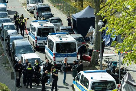 Polizisten und Beamte der Spurensicherung in weißen Schutzanzügen stehen an dem Ort, wo ein toter Mann gefunden wurde. Polizisten und Beamte der Spurensicherung in weißen Schutzanzügen stehen an dem Ort, wo ein toter Mann gefunden wurde.
