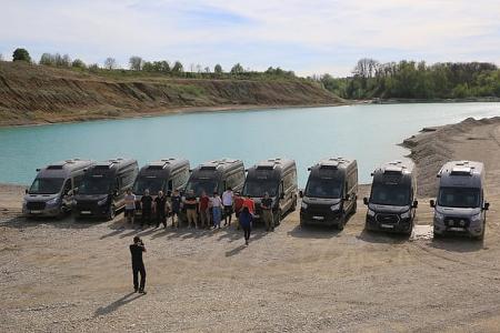 Offroad-Fahrtraining: Teilnehmer und ihre Busse vor dem See
