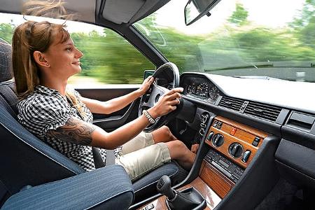 Frau am Steuer eines Mercedes 300 CE