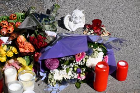 Zeichen der Anteilnahme: Auf einem Bürgersteig an dem Spielplatz sind Kerzen und Blumen niedergelegt worden.