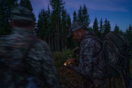 Zwei Jäger schauen nachts auf ihre Wärmebildkameras