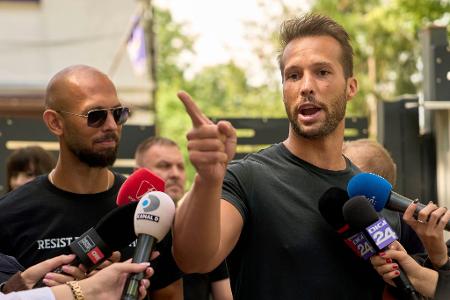 Andrew Tate (links) schaut zu seinem Bruder Tristan Tate, der am 21. Mai vor einer Polizeistation in Voluntari in Rumänien redete. Andrew Tate (links) schaut zu seinem Bruder Tristan Tate, der am 21. Mai vor einer Polizeistation in Voluntari in Rumänien redete.