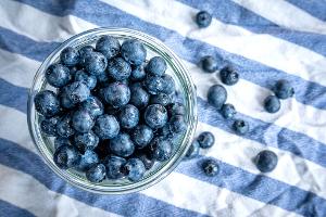Beeren statt Chips oder Nüsschen: Heidelbeeren, auch Blaubeeren genannt, liegen auf einem Esstisch und werden gern gesnackt.