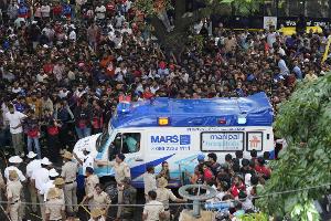 Ein Krankenwagen bahnt sich den Weg durch eine Menschenmenge am M. Chinnaswamy-Stadion in der indischen Stadt Bengaluru. 