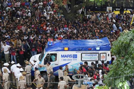 Ein Krankenwagen bahnt sich den Weg durch eine Menschenmenge am M. Chinnaswamy-Stadion in der indischen Stadt Bengaluru. Ein Krankenwagen bahnt sich den Weg durch eine Menschenmenge am M. Chinnaswamy-Stadion in der indischen Stadt Bengaluru.