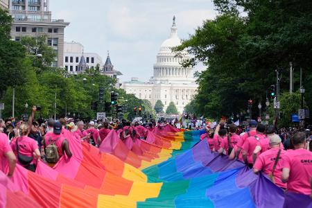 Mit riesigen Regenbogenfahnen demonstrieren Menschen mit Blick auf das US-Kapitol bei einer Pride-Parade in Washington für die Rechte der LGBTQI+-Gemeinschaft. Mit riesigen Regenbogenfahnen demonstrieren Menschen mit Blick auf das US-Kapitol bei einer Pride-Parade in Washington für die Rechte der LGBTQI+-Gemeinschaft.