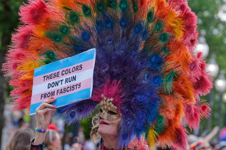 Auf dem Plakat eines Pride-Teilnehmers steht: 