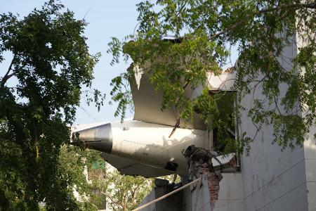 Trümmer des Flugzeugs ragen aus einem Gebäude.