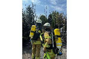 Ausgedehnter Heckenbrand mit Wohnwagen in Vollbrand