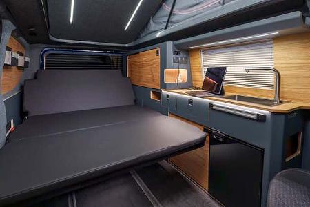 Campervan Pureflexx Escape 500 aufgebaute Schlafsitzbank neben erleuchteten Küche