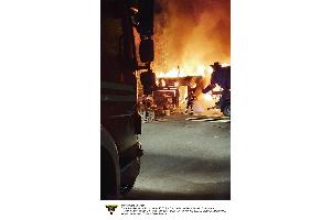 Einsatzkräfte der Feuerwehr München bei einem Brandeinsatz auf einem Betriebsgelände.