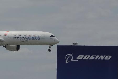 Die zwei großen Konkurrenten: Ein Airbus fliegt bei einer Vorführung auf der Luftfahrtmesse Salon du Bourget an einem Logo von Boeing vorbei. Die zwei großen Konkurrenten: Ein Airbus fliegt bei einer Vorführung auf der Luftfahrtmesse Salon du Bourget an einem Logo von Boeing vorbei.