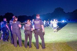 Einsatzkräfte der Polizei und Jugendliche stehen sich im Hamburger Stadtpark gegenüber. 