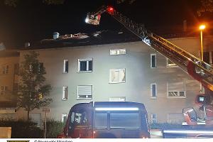 Eine Drehleiter steht vor dem Mehrfamilienhaus.