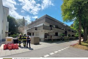 Einsatzkräfte der Feuerwehr vor dem Gebäude.