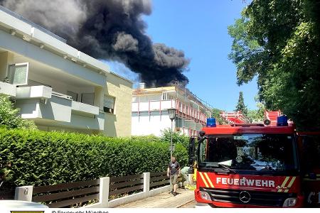 Einsatzkräfte der Feuerwehr München bei einem Brand auf einem Dach. Einsatzkräfte der Feuerwehr München bei einem Brand auf einem Dach.