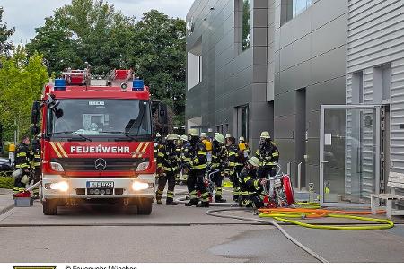 Ein Hilfeleistungslöschfahrzeug und ausgerüstete Feuerwehrmänner. Ein Hilfeleistungslöschfahrzeug und ausgerüstete Feuerwehrmänner.